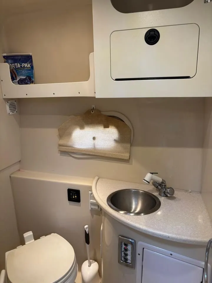 Slide: The Image of 2009 Four Winns 288 Vista boat bathroom with sink, toilet, and storage compartments. - 8
