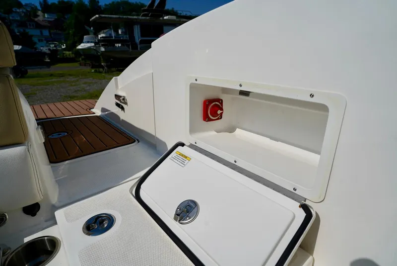 Slide: The Image of 2018 Sea Ray SPX 230 boat interior with storage compartment and control panel. - 28