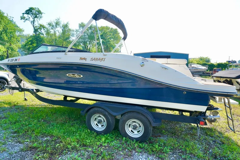 Slide: The Image of 2018 Sea Ray SPX 230 boat on trailer, parked on grass, with trees in background. - 3