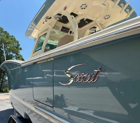 Slide: The Image of 2018 Scout 355 LXF boat with sleek design, docked outdoors. - 11