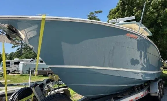 Slide: The Image of 2018 Scout 355 LXF boat on trailer under clear blue sky. - 14