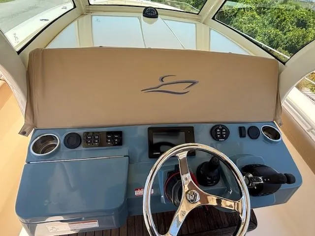 Slide: The Image of 2018 Scout 355 LXF boat with beige leather seating and steering wheel. - 26