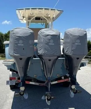 Slide: The Image of 2018 Scout 355 LXF boat on trailer with Yamaha engines, parked outdoors. - 3