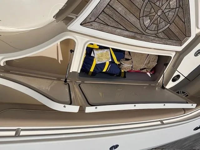 Slide: The Image of 2018 Scout 355 LXF boat interior with beige seating and storage compartments. - 37