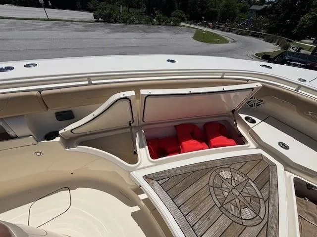 Slide: The Image of 2018 Scout 355 LXF boat deck with seating, under a clear blue sky. - 38