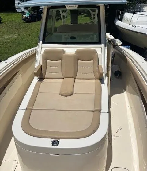 Slide: The Image of 2018 Scout 355 LXF boat seating area with beige cushions and cup holders. - 46