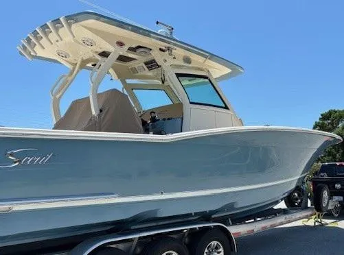 Slide: The Image of 2018 Scout 355 LXF boat with triple Yamaha engines on a trailer. - 5
