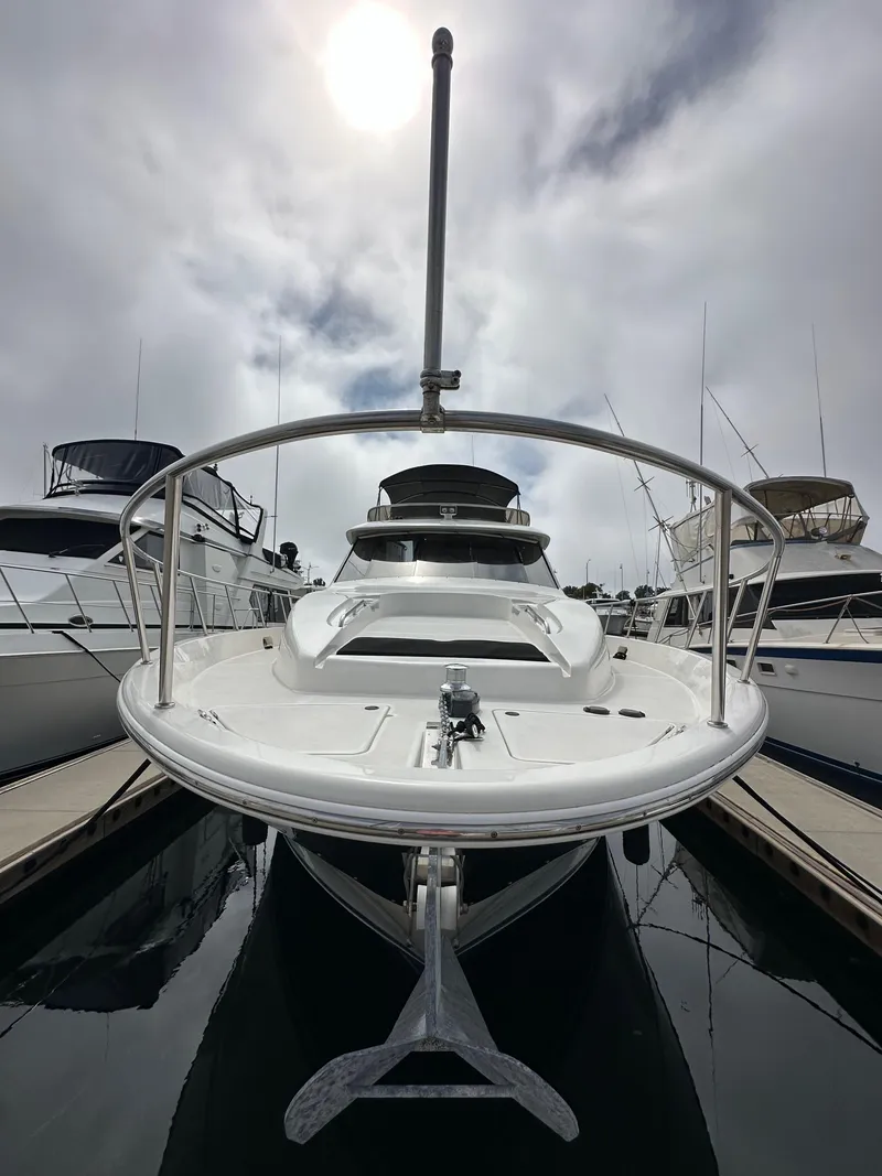 Slide: The Image of 2004 Meridian 580 Pilothouse yacht docked, viewed from the front under a cloudy sky. - 18