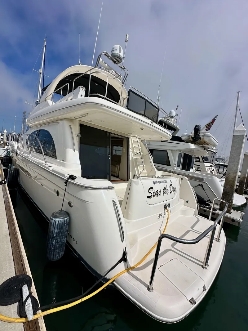 Slide: The Image of 2004 Meridian 580 Pilothouse yacht docked at marina, featuring spacious deck and elegant design. - 24