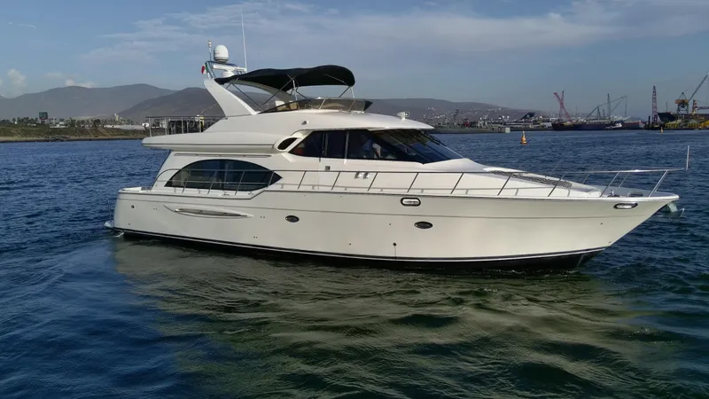 Slide: The Image of 2004 Meridian 580 Pilothouse yacht on calm water with scenic background. - 5