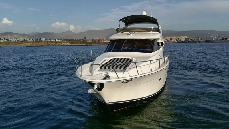 Slide: The Image of 2004 Meridian 580 Pilothouse yacht cruising on calm waters with scenic mountain backdrop. - 6