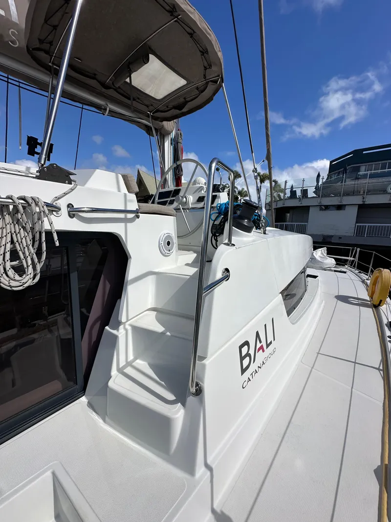 Slide: The Image of 2023 Bali 4.2 catamaran with sleek design, docked under clear blue skies. - 10