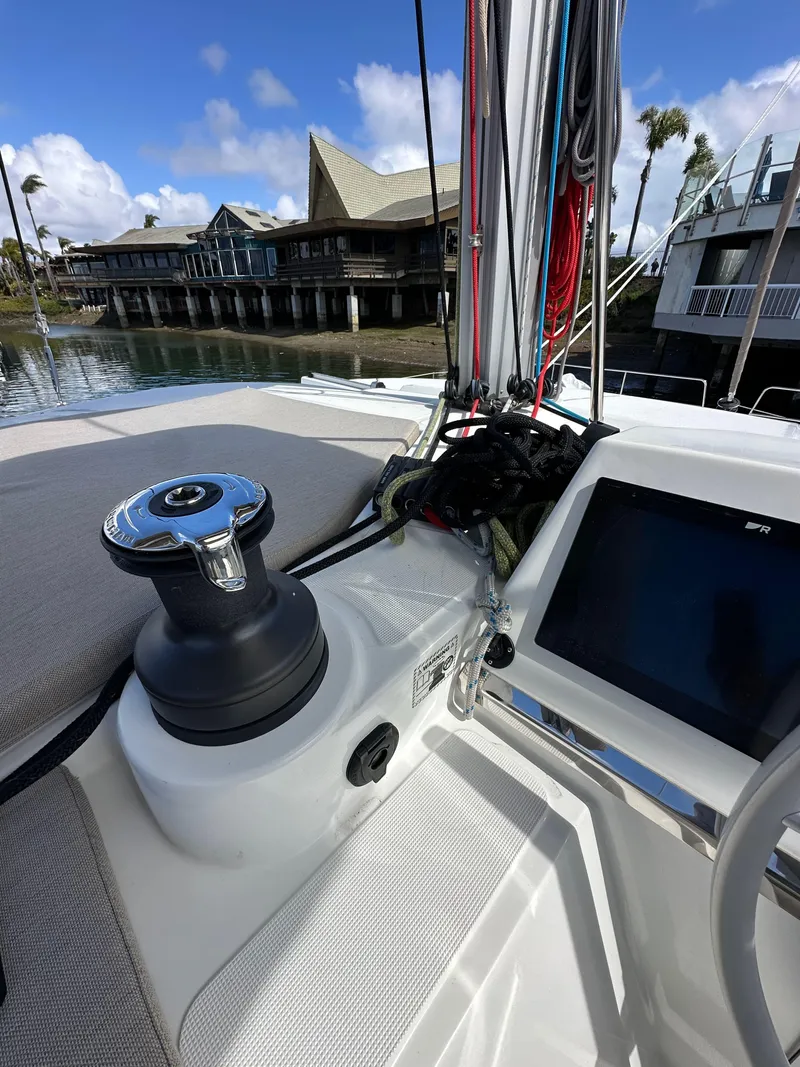 Slide: The Image of 2023 Bali 4.2 sailboat deck with winch and control panel, docked near waterfront buildings. - 12