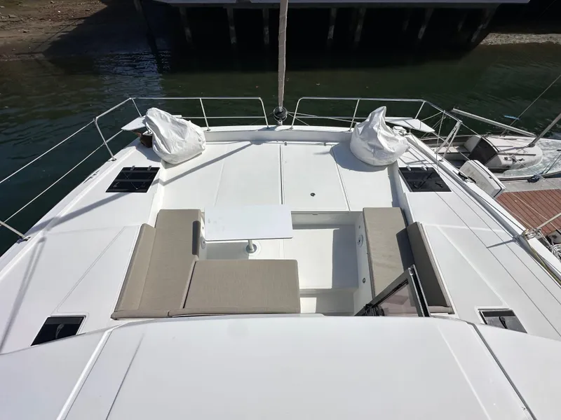 Slide: The Image of 2023 Bali 4.2 yacht deck with seating and table, docked by the water. - 18