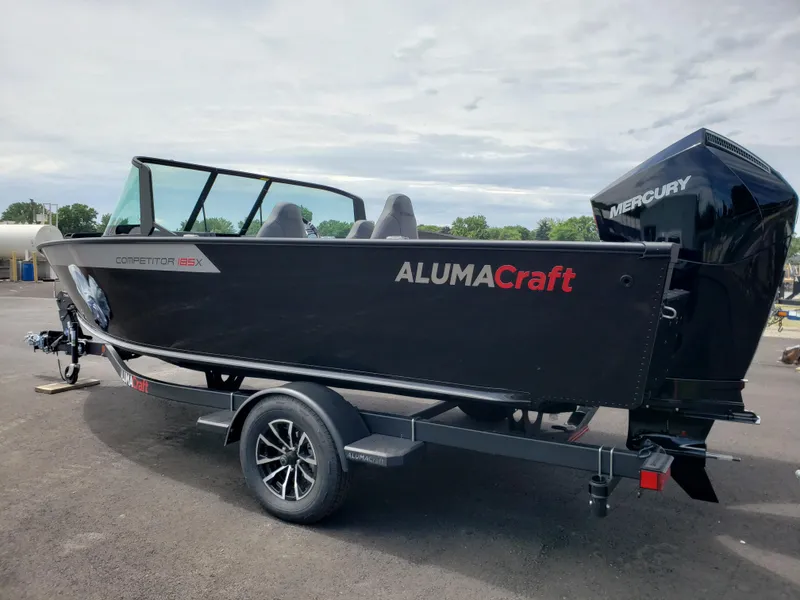 The Image of 2025 Alumacraft Competitor 185X Sport boat on trailer, featuring Mercury outboard motor. - 0