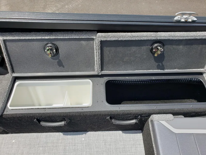 Slide: The Image of 2025 Alumacraft Competitor 185X Sport boat storage compartments with secure locks and handles. - 11