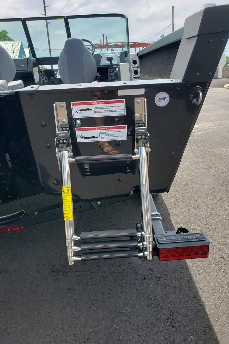 Slide: The Image of 2025 Alumacraft Competitor 185X Sport boat with rear ladder and safety labels. - 5