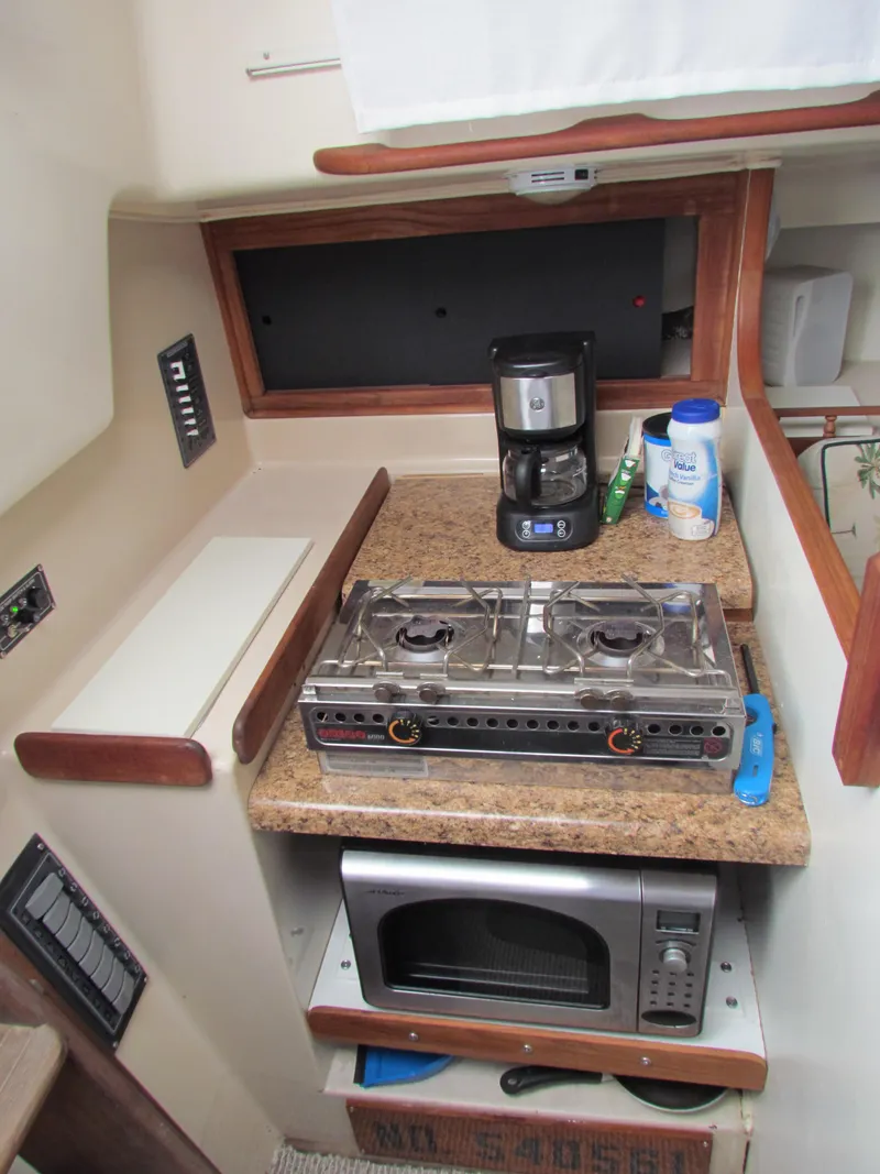 Slide: The Image of 1972 Morgan 35 yacht interior with kitchen, sink, stove, and wooden cabinetry. - 11