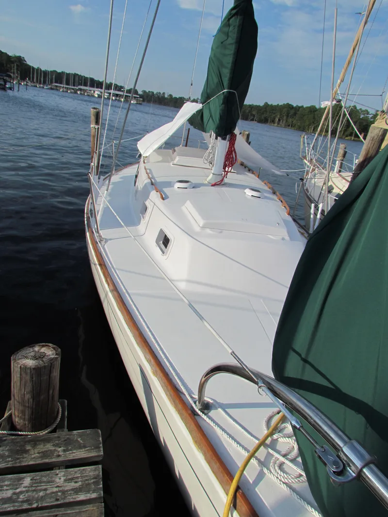 Slide: The Image of 1972 Morgan 35 sailboat interior with green cushioned seating and a floral tablecloth. - 15