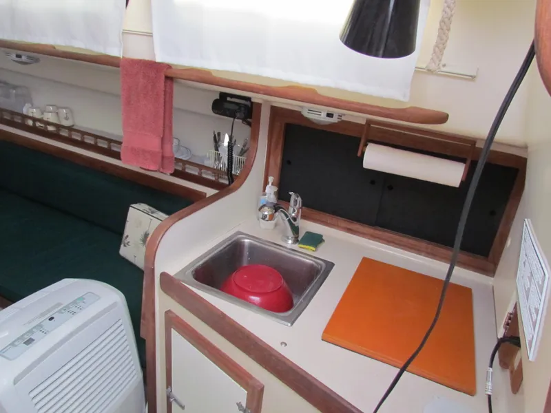 Slide: The Image of 1972 Morgan 35 boat interior with stove, water bottle, and alcohol can on shelves. - 22