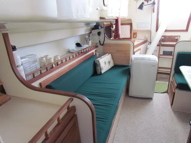 Slide: The Image of 1972 Morgan 35 boat interior with green seating, table, and portholes. - 28