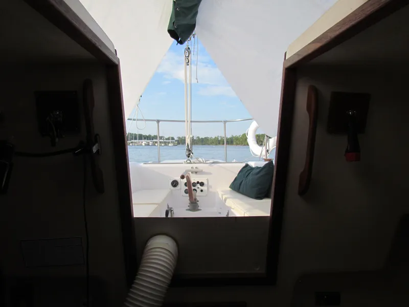 Slide: The Image of 1972 Morgan 35 sailboat interior with green seating and fern-patterned tablecloth. - 29