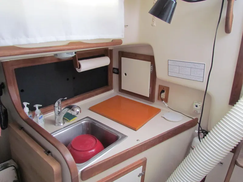 Slide: The Image of Interior of a 1972 Morgan 35 sailboat with green seating and a patterned tablecloth. - 30