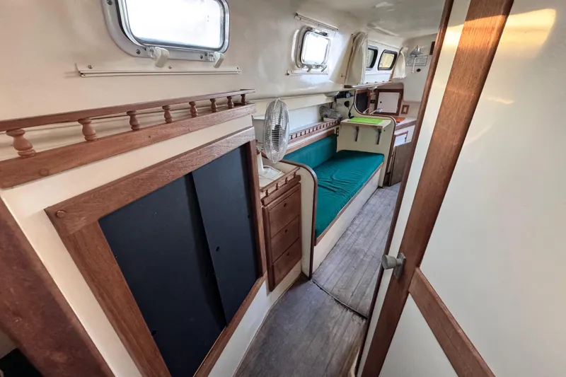 Slide: The Image of 1972 Morgan 35 sailboat interior with wooden accents and green cushioned seating. - 37