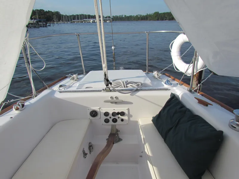 Slide: The Image of 1972 Morgan 35 sailboat cockpit with winches, ropes, and wooden accents at dock. - 6