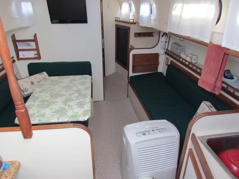 Slide: The Image of 1972 Morgan 35 sailboat docked, featuring green sail cover and wooden hatch. - 7