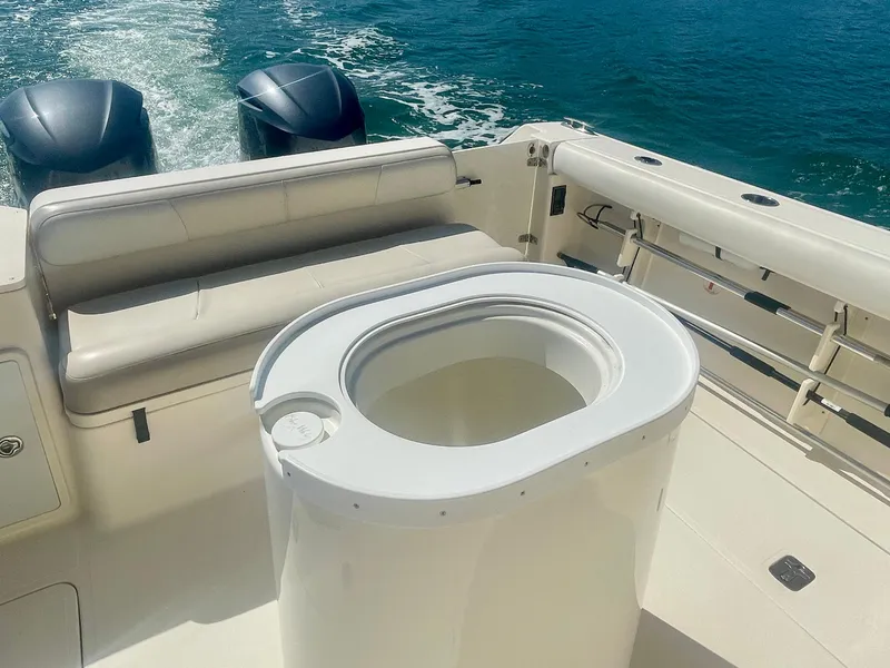 Slide: The Image of 2011 Pursuit 315 Offshore boat interior with seating and dual engines on the water. - 16