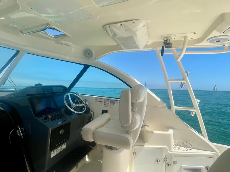 Slide: The Image of Interior view of 2011 Pursuit 315 Offshore boat with ocean and sailboats in background. - 19