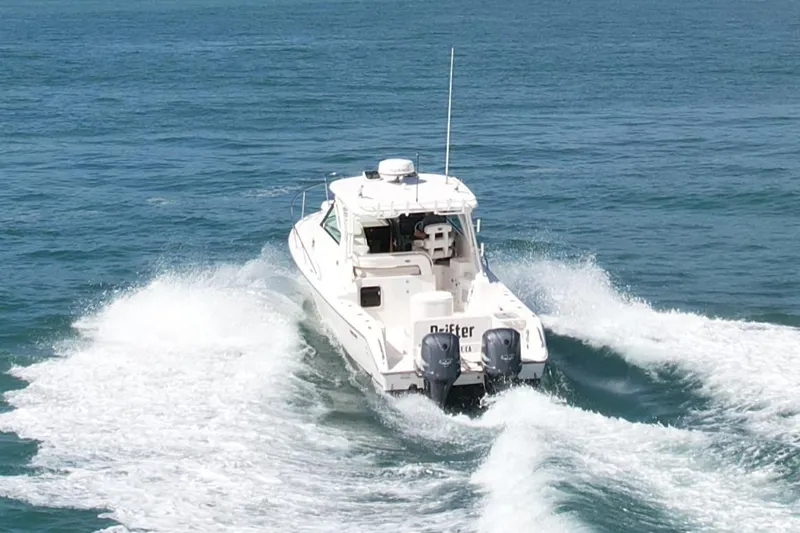 Slide: The Image of 2011 Pursuit 315 Offshore boat cruising on open water, rear view. - 2