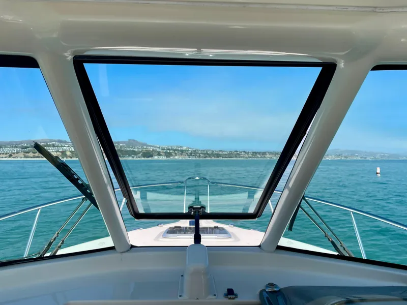 Slide: The Image of View from 2011 Pursuit 315 Offshore boat cockpit, overlooking calm blue waters and distant shoreline. - 21