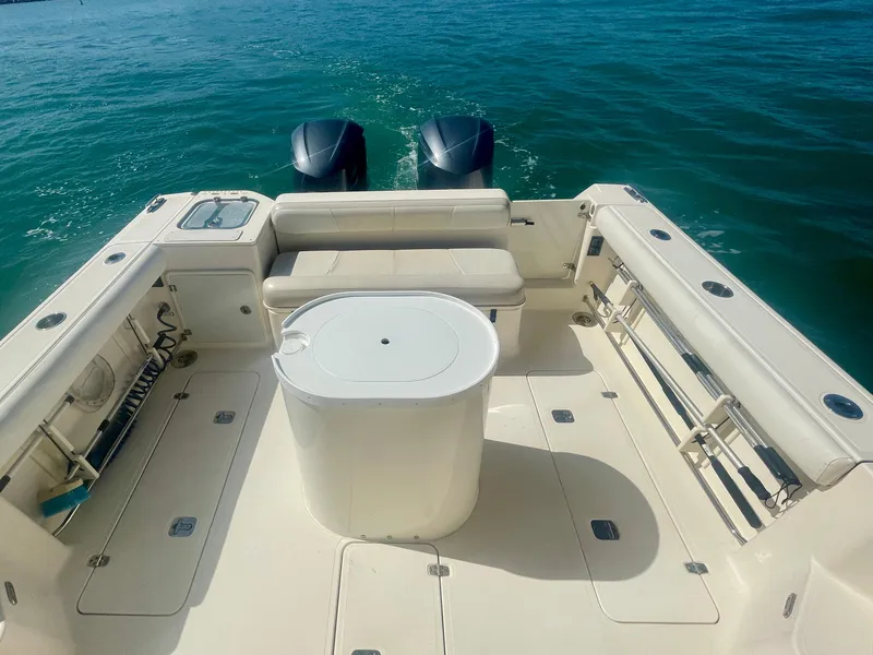 Slide: The Image of 2011 Pursuit 315 Offshore boat deck with seating and twin engines on open water. - 23