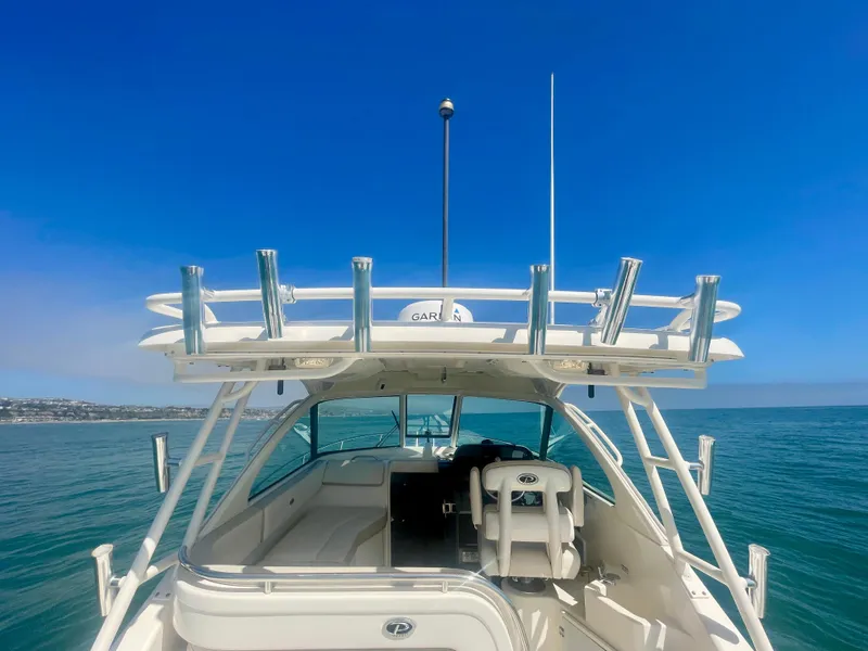 Slide: The Image of 2011 Pursuit 315 Offshore boat on calm sea under clear blue sky. - 25