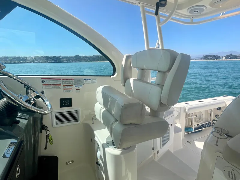 Slide: The Image of Interior of 2011 Pursuit 315 Offshore boat with helm and seating, overlooking ocean. - 36