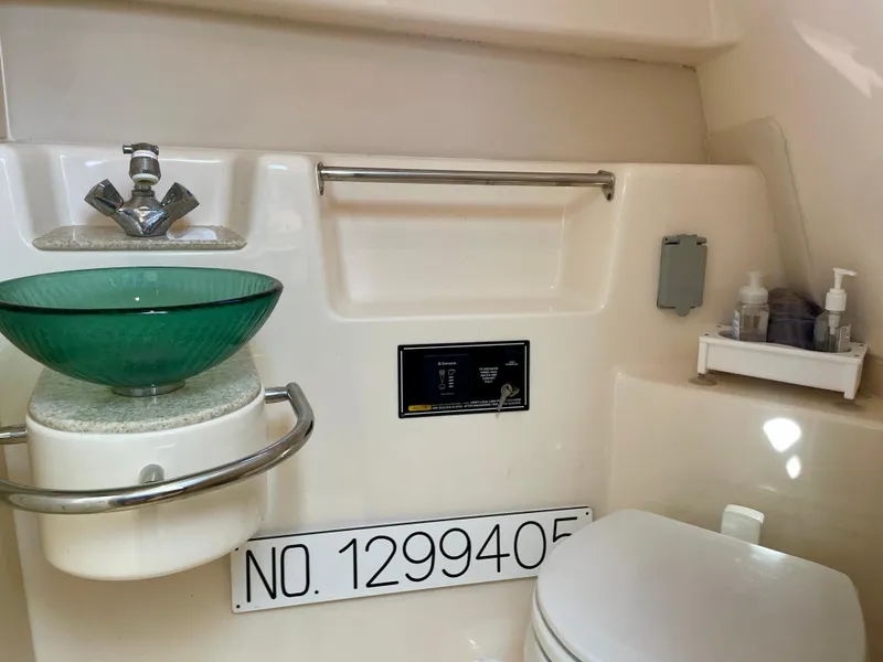 Slide: The Image of 2011 Pursuit 315 Offshore boat bathroom with green glass sink and toilet. - 38