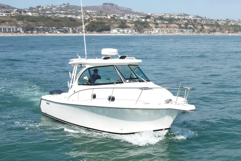 Slide: The Image of 2011 Pursuit 315 Offshore boat cruising on ocean near coastal landscape. - 4