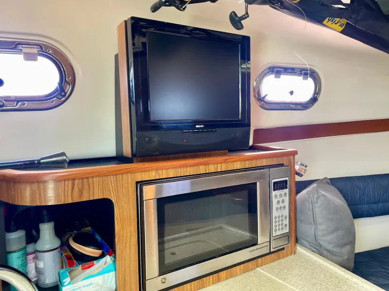 Slide: The Image of Interior of 2011 Pursuit 315 Offshore boat with TV, microwave, and portholes. - 41