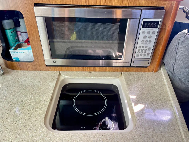 Slide: The Image of Compact kitchen area in a 2011 Pursuit 315 Offshore boat with microwave and stove. - 42