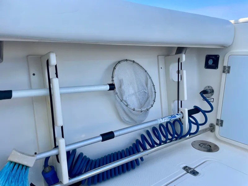 Slide: The Image of 2011 Pursuit 315 Offshore boat deck with fishing net and coiled hose. - 45