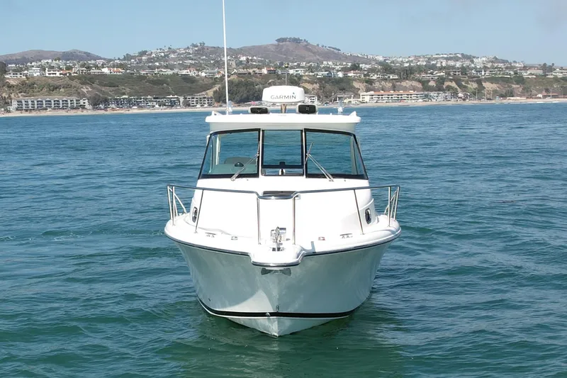 Slide: The Image of 2011 Pursuit 315 Offshore boat on calm ocean near coastal town. - 8