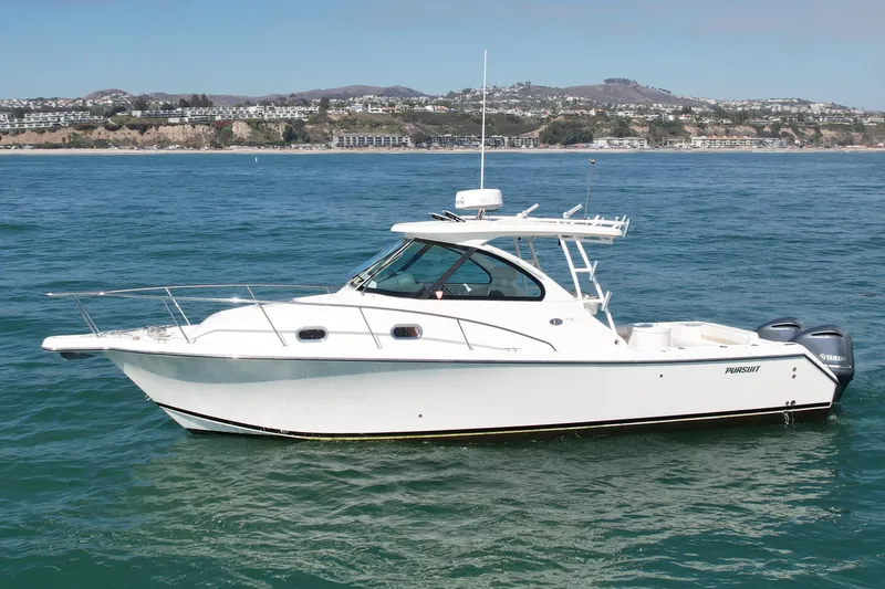 Slide: The Image of 2011 Pursuit 315 Offshore boat on calm ocean waters, coastal background. - 9