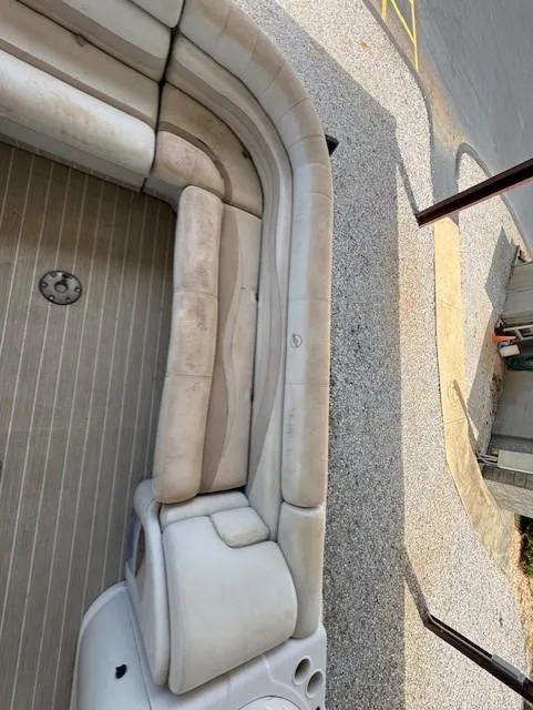 Slide: The Image of 2006 Starcraft Elite 246 RE CR boat interior with beige seating and wooden flooring. - 10