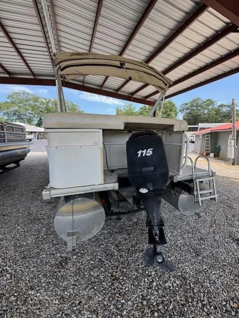 Slide: The Image of 2006 Starcraft Elite 246 RE CR pontoon boat with 115 HP motor under a metal canopy. - 11