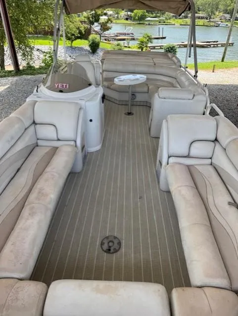 Slide: The Image of 2006 Starcraft Elite 246 RE CR pontoon boat with beige seating and lake view. - 3