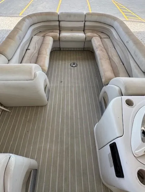 Slide: The Image of 2006 Starcraft Elite 246 RE CR boat interior with beige seating and striped flooring. - 5