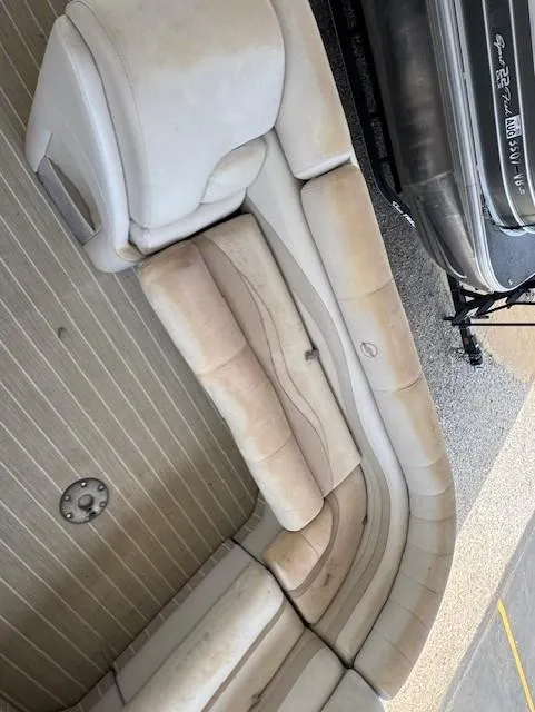 Slide: The Image of 2006 Starcraft Elite 246 RE CR boat interior with beige seating and striped flooring. - 9