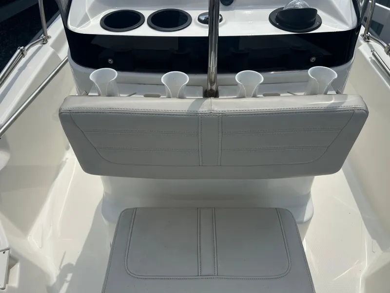 Slide: The Image of 2018 Boston Whaler 150 Montauk boat interior with white seating and cup holders. - 13